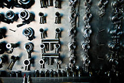 A rack of various stainless steel winemaking tools