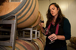 Alison Crowe with a pipette sampling red wine from the barrel